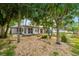 Backyard featuring a gravel landscape, a red door, and mature trees providing privacy and shade at 4265 Conway Place Cir, Orlando, FL 32812