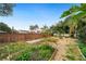 Backyard with a wooden pergola, garden beds, brick fence, and gravel ground covering at 4265 Conway Place Cir, Orlando, FL 32812