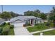Aerial view of a single-story home with lush landscaping, a manicured lawn, and a driveway at 4265 Conway Place Cir, Orlando, FL 32812