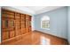 Home office features wood floors, a large window, and a custom built-in bookshelf with a ladder at 4265 Conway Place Cir, Orlando, FL 32812