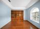 Home office featuring wood floors, a large window, and a custom built-in bookshelf with a ladder at 4265 Conway Place Cir, Orlando, FL 32812