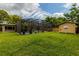 Spacious backyard with a pool and pool house, enclosed within a screen, surrounded by a lush green lawn at 502 Oak Ln, Maitland, FL 32751