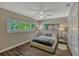 This bedroom has neutral walls, wood floors, a ceiling fan, and two large windows for ample natural light at 502 Oak Ln, Maitland, FL 32751