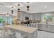 This well-lit kitchen features grey cabinets, stainless steel appliances, a breakfast bar, and stylish pendant lighting at 502 Oak Ln, Maitland, FL 32751