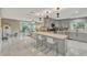 Bright, open kitchen with white marble floors, grey cabinets, an island, and seamless access to the living room at 502 Oak Ln, Maitland, FL 32751