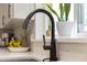 Close-up of a modern black kitchen faucet with a window view and countertop details at 502 Oak Ln, Maitland, FL 32751