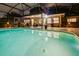 Evening shot of the swimming pool showcasing landscape lighting, patio and adjacent grill and food prep area at 502 Oak Ln, Maitland, FL 32751