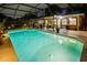 Evening view of a backyard pool featuring landscape lighting, comfortable patio seating and nearby outdoor grill at 502 Oak Ln, Maitland, FL 32751