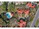Aerial view of residences featuring red tile roofs surrounding a beautiful community pool area with lush landscaping at 546 Via Fontana Dr # 203, Altamonte Springs, FL 32714