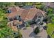 An aerial view of a stunning house with a brick driveway, tile roof, and a screened in pool at 5909 Oxford Moor Blvd, Windermere, FL 34786