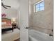 Bedroom leading into a bathroom with a window, tiled walls and a white soaking tub at 5909 Oxford Moor Blvd, Windermere, FL 34786