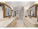 Bright bathroom with dual vanities, decorative mirrors, and a stunning chandelier, creating a luxurious feel at 5909 Oxford Moor Blvd, Windermere, FL 34786