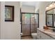 Bathroom with a stand up shower featuring stone tile and glass doors, and a granite countertop sink at 5909 Oxford Moor Blvd, Windermere, FL 34786