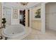 Elegant bathroom with tiled tub, illuminated by chandelier, and a hidden door leading to another room at 5909 Oxford Moor Blvd, Windermere, FL 34786