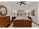 Comfortable bedroom featuring natural light, tropical themed artwork, and elegant wooden furniture at 5909 Oxford Moor Blvd, Windermere, FL 34786
