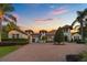 Beautiful exterior home shot with lush landscaping, brick driveway, and a connected garage at 5909 Oxford Moor Blvd, Windermere, FL 34786