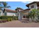 Side exterior showcasing tile roof, porte cochere, lush greenery, and brick driveway at 5909 Oxford Moor Blvd, Windermere, FL 34786