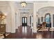 Grand foyer featuring dark hardwood floors, arched entryways, and views into the dining and living rooms at 5909 Oxford Moor Blvd, Windermere, FL 34786