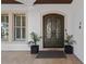Elegant double front door with decorative wrought iron detailing, flanked by potted plants at 5909 Oxford Moor Blvd, Windermere, FL 34786