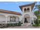 Exterior of home featuring a tiled roof, tower, arched entry, and manicured landscaping at 5909 Oxford Moor Blvd, Windermere, FL 34786