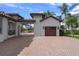 Garage with tile roof and wood doors, connected by a porte cochere to the main house at 5909 Oxford Moor Blvd, Windermere, FL 34786