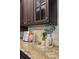 Close up of granite countertop with decorative accessories, tiled backsplash, and dark wood cabinets at 5909 Oxford Moor Blvd, Windermere, FL 34786