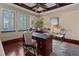 An executive office with a sleek desk, elegant seating, and large windows providing ample natural light at 5909 Oxford Moor Blvd, Windermere, FL 34786