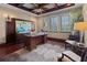An office with wooden furniture, decor, and a ceiling fan above a dark wooden coffered ceiling and a soft, neutral-toned rug at 5909 Oxford Moor Blvd, Windermere, FL 34786
