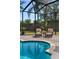A luxury outdoor pool with comfortable lounge chairs and a black metal enclosure at 5909 Oxford Moor Blvd, Windermere, FL 34786