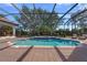 Beautiful backyard pool with lovely tile spa, brick patio, and black metal enclosure at 5909 Oxford Moor Blvd, Windermere, FL 34786