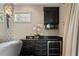 Convenient wet bar features dark cabinetry, granite countertops, a sink, a microwave, and a wine refrigerator at 5909 Oxford Moor Blvd, Windermere, FL 34786