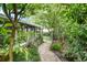 Landscaped backyard pathway leading to a fenced area, surrounded by lush foliage at 627 Darcey Dr, Winter Park, FL 32792