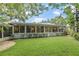 A well-maintained backyard with a lush lawn and a sunroom with many windows at 627 Darcey Dr, Winter Park, FL 32792