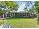 Grassy backyard and mature trees behind the home at 627 Darcey Dr, Winter Park, FL 32792