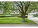 Charming one-story home with mature trees, a lush green lawn, and a two-car garage at 627 Darcey Dr, Winter Park, FL 32792