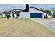 Modern two-story home featuring a blue garage door, stylish black trim and solar panels at 6653 Se 87Th St, Ocala, FL 34472