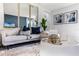 This living room features a light colored sofa, artwork and a decorative table with a contemporary design at 7173 Cow Prairie Rd, St Cloud, FL 34773