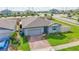 Aerial view of a well-kept home with a brick driveway, lush lawn, and fenced backyard at 719 Tortugas St, Haines City, FL 33844
