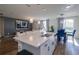 Modern kitchen island with a sink and adjacent dining area, overlooking a cozy living room at 719 Tortugas St, Haines City, FL 33844