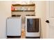 Bright laundry room features a full-size washer and dryer and built-in shelving for storage at 719 Tortugas St, Haines City, FL 33844