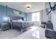 Main bedroom with light blue walls, white floors, and a plush upholstered bed with adjacent seating area at 719 Tortugas St, Haines City, FL 33844