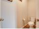 Small, neutral powder room with toilet, wood flooring, and minimalist decor at 719 Tortugas St, Haines City, FL 33844