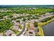 Neighborhood aerial view of homes, a lake, and lush landscaping on a sunny day at 7288 Winding Lake Cir, Oviedo, FL 32765