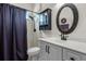 Well-lit bathroom featuring a vanity with black hardware, an oval mirror, and a shower at 7288 Winding Lake Cir, Oviedo, FL 32765