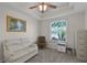 Carpeted room featuring a ceiling fan, furniture, and a bright window with privacy blinds at 7288 Winding Lake Cir, Oviedo, FL 32765