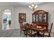 Elegant dining room with chandelier, a large china cabinet, and an arched doorway to living room at 7288 Winding Lake Cir, Oviedo, FL 32765