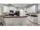 Well-lit kitchen featuring white cabinets, dark countertops, black appliances, and an open breakfast bar at 7288 Winding Lake Cir, Oviedo, FL 32765