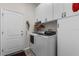 Bright laundry room with white cabinetry above new, front-loading washer and dryer at 7288 Winding Lake Cir, Oviedo, FL 32765