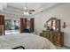 A primary bedroom featuring a king bed, tray ceiling, and a large dresser at 7288 Winding Lake Cir, Oviedo, FL 32765