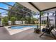 Backyard pool and spa featuring a screened-in enclosure, patio, and lush landscaping at 7288 Winding Lake Cir, Oviedo, FL 32765